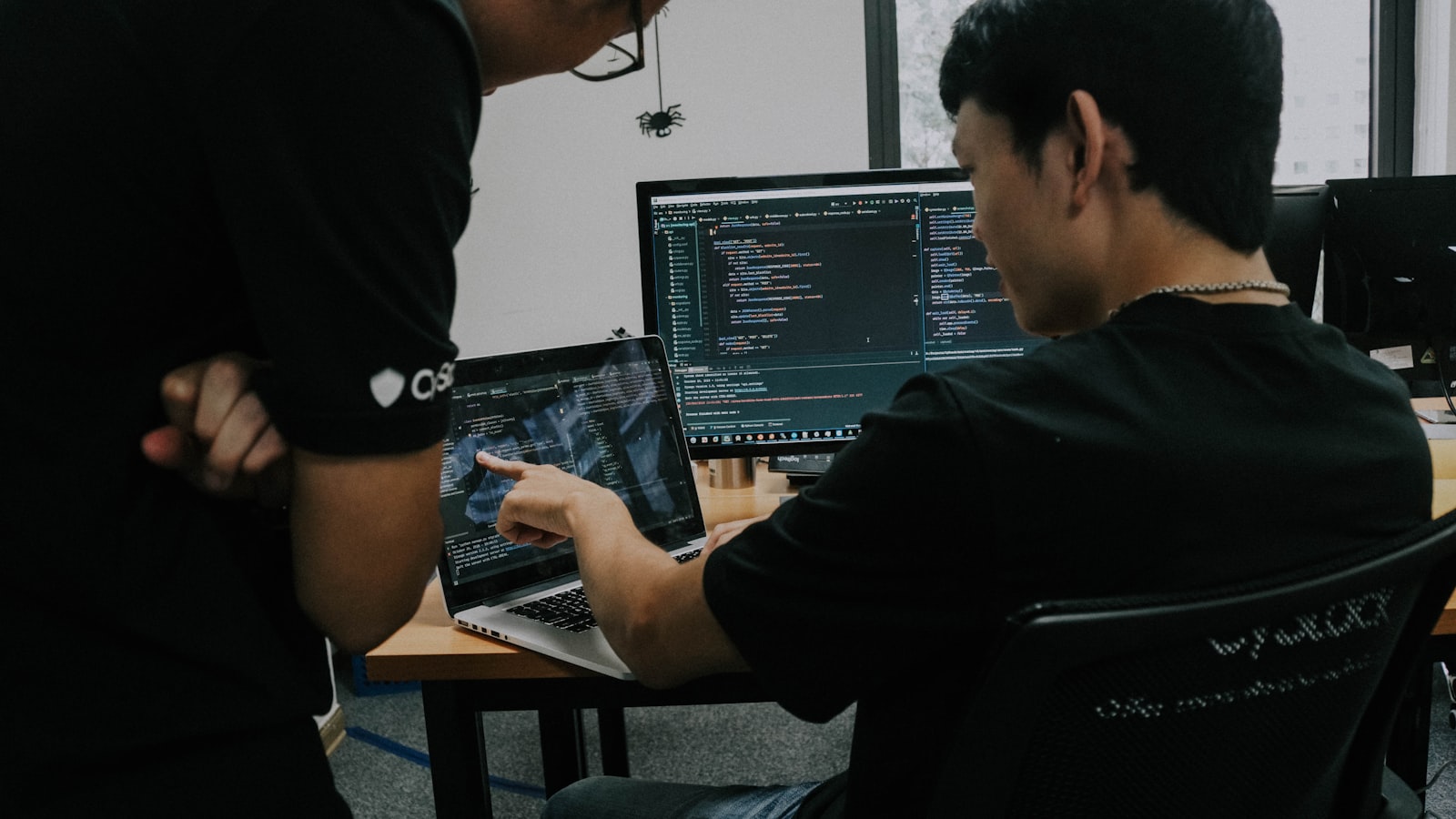 two demand-gen professionals working side by side at computer workstations reviewing campaign data