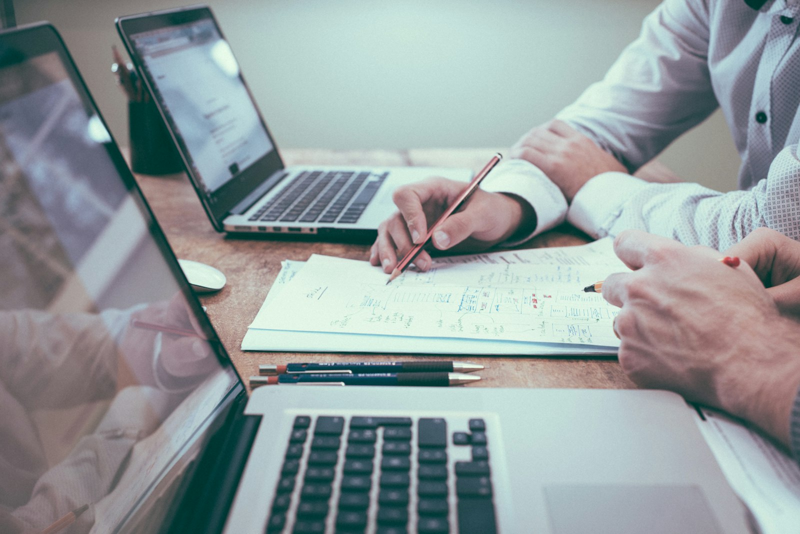professional reviewing CRM records and documents with laptop on desk