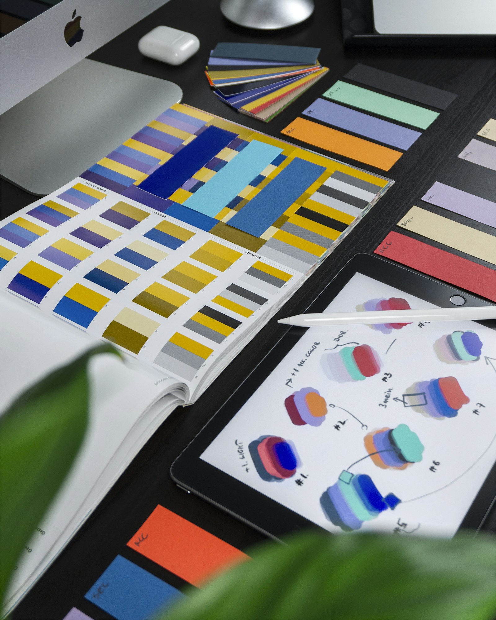 graphic designers working with color swatches and brand materials at desk