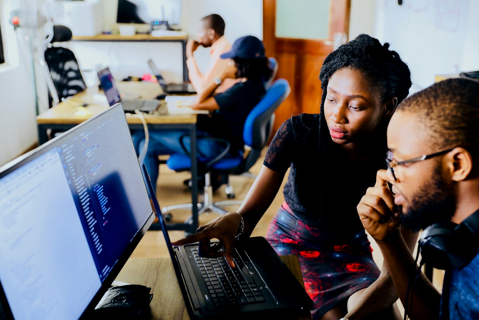 diverse team collaborating at laptops in meeting room for multi-agent campaign oversight