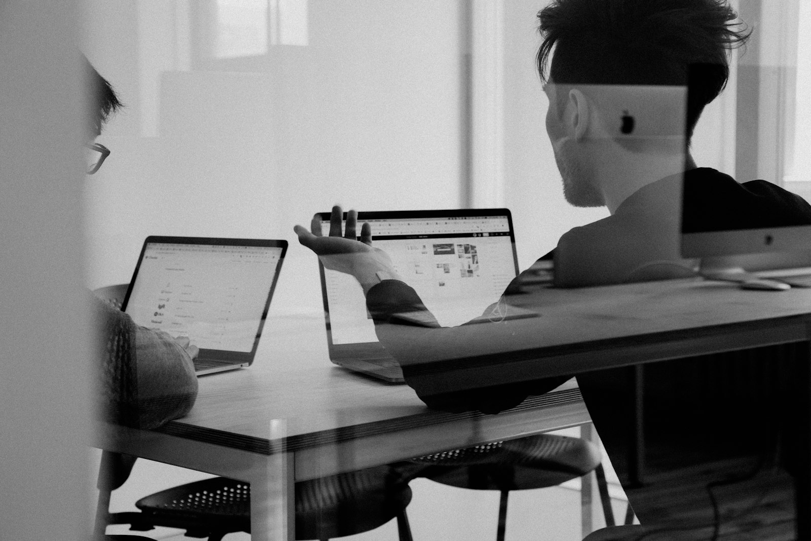 two RevOps colleagues reviewing pipeline charts at a shared desk